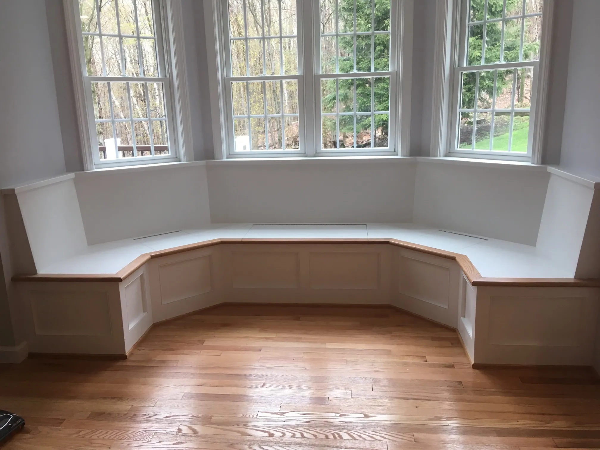 Custom bay window banquette seating with built-in storage