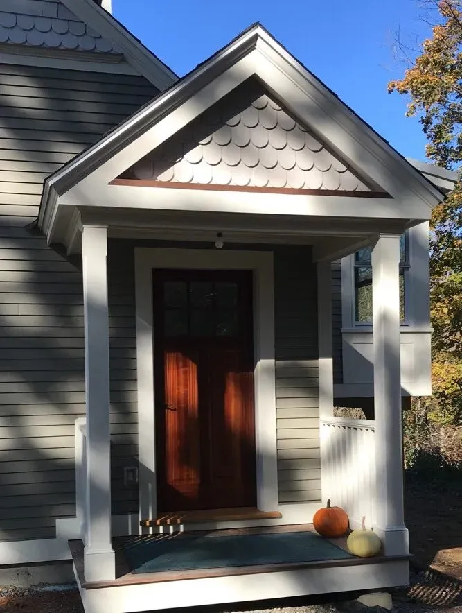 Custom entry portico with fish-scale shingle gable